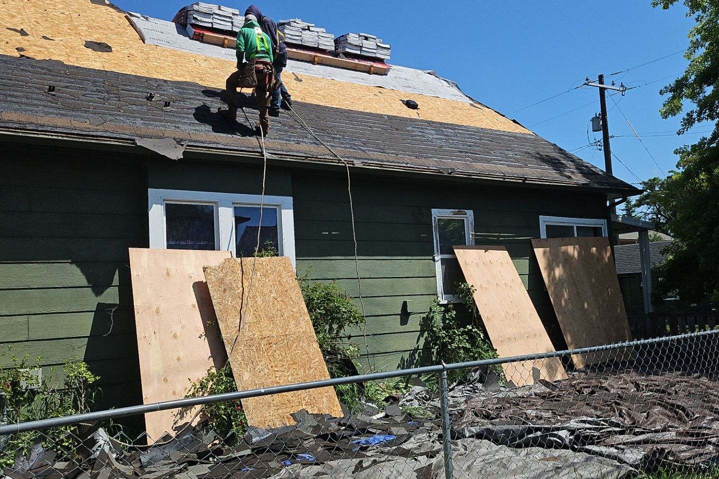 Spokane home stripped to the roof decking with boarded windows during a storm-damage insurance rebuild