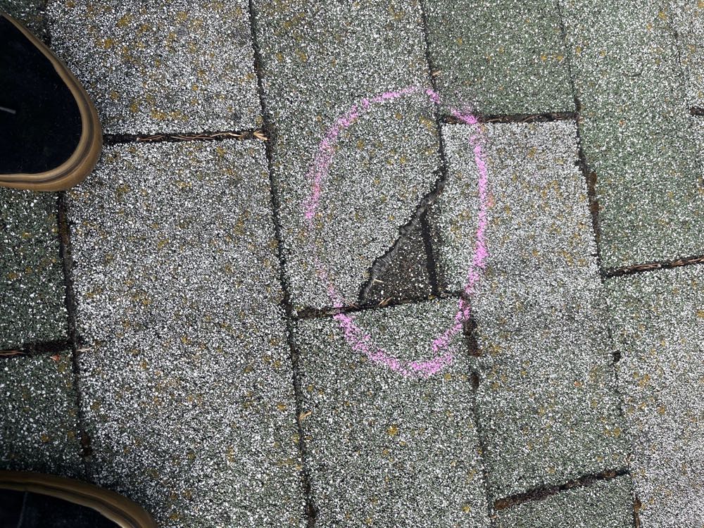 Storm-damaged shingle circled during a Peaks & Valleys inspection